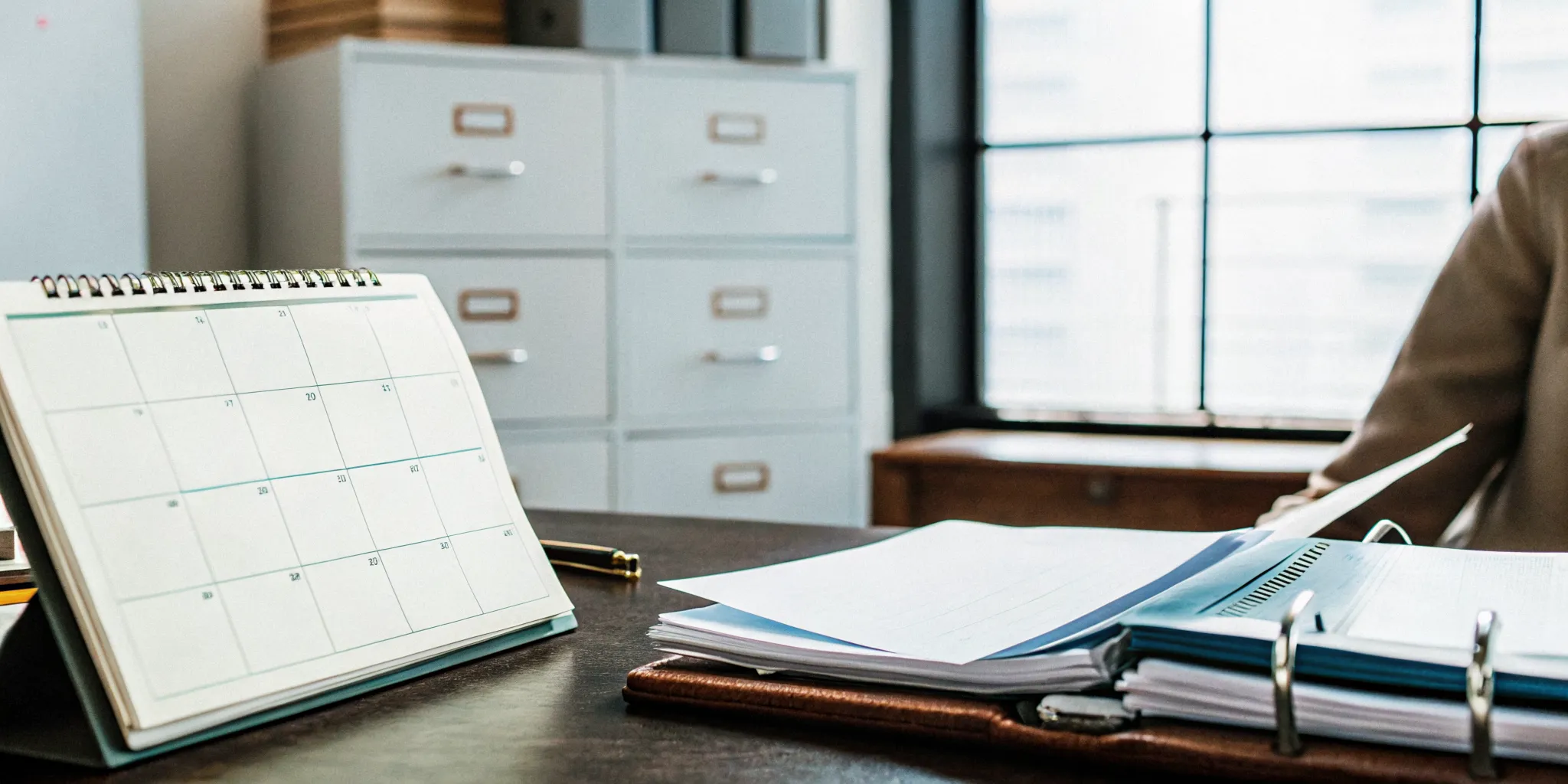 Benefits compliance calendar and employer documents on a professional office desk
